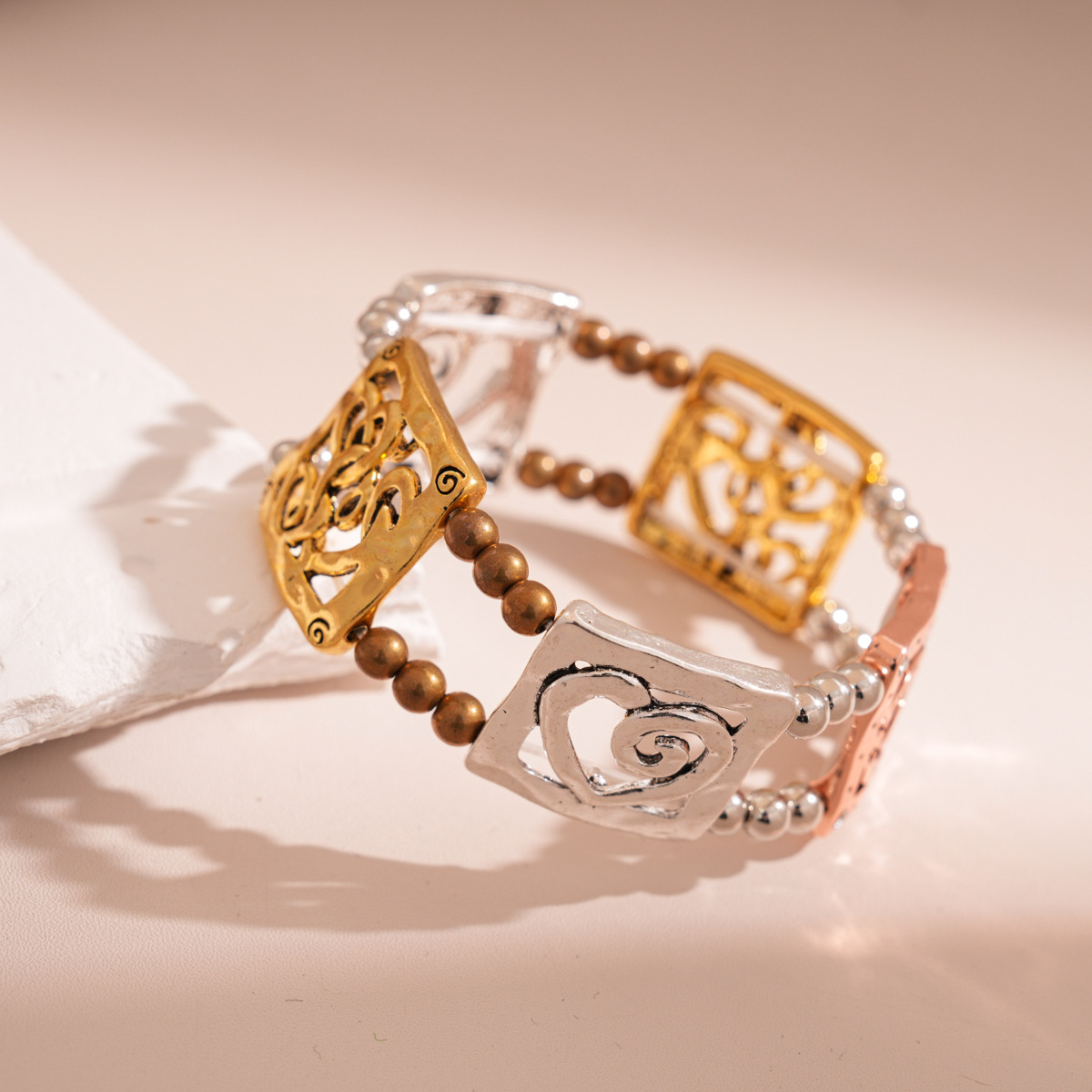 Square, hollowed-out heart-shaped pieces are used to create this stylish and luxurious bracelet. It is a feminine, retro, and ethnic-style accessory.