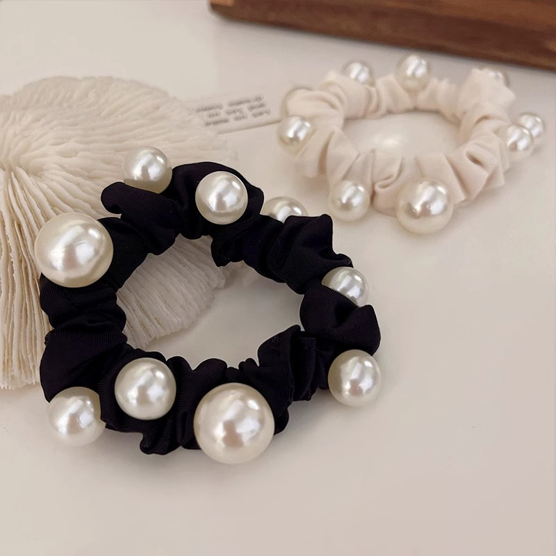 Elegant pearl hair tie, minimalist style, sophisticated look, perfect for a ponytail or hair tie.
