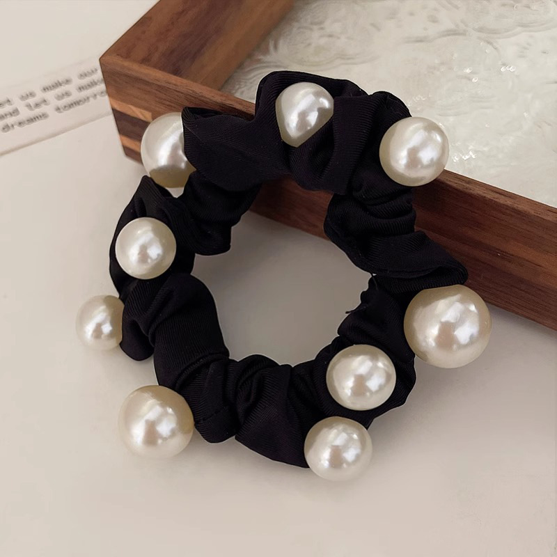 Elegant pearl hair tie, minimalist style, sophisticated look, perfect for a ponytail or hair tie.