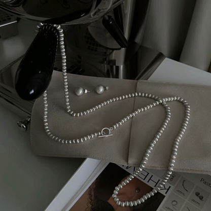 Round, brushed finish clavicle chain earrings with a unique design, exuding a sophisticated and luxurious feel. A long, intricately crafted sweater chain.