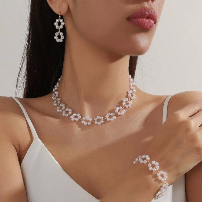 A luxurious three-piece set of pearl necklace, bracelet, and earrings with a bohemian design.