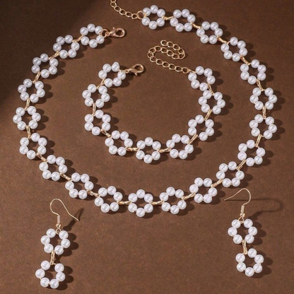 A luxurious three-piece set of pearl necklace, bracelet, and earrings with a bohemian design.