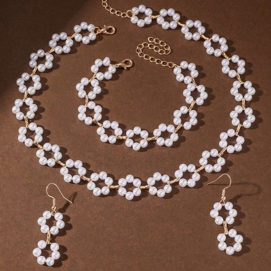 A luxurious three-piece set of pearl necklace, bracelet, and earrings with a bohemian design.