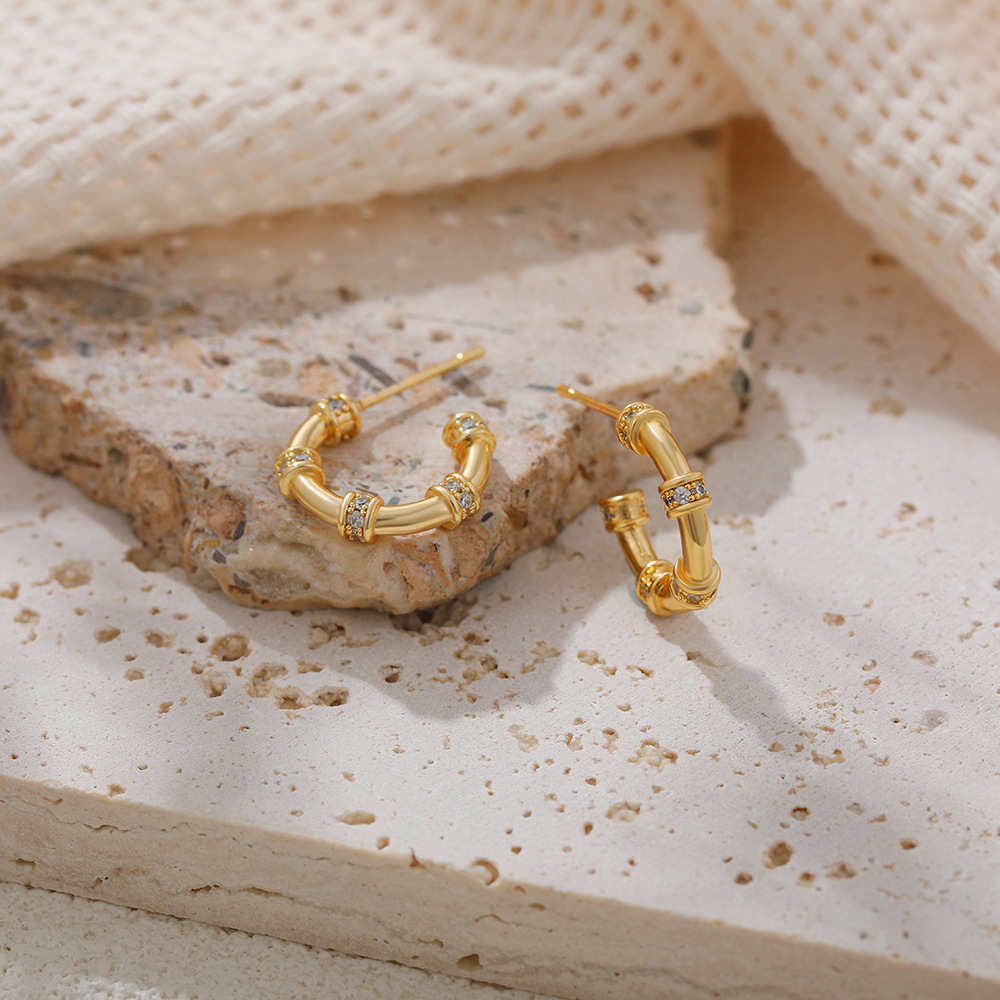 Solid gold C-shaped earrings with zircon inlay, bamboo-shaped circle design, understated luxury and fashionable stud earrings.