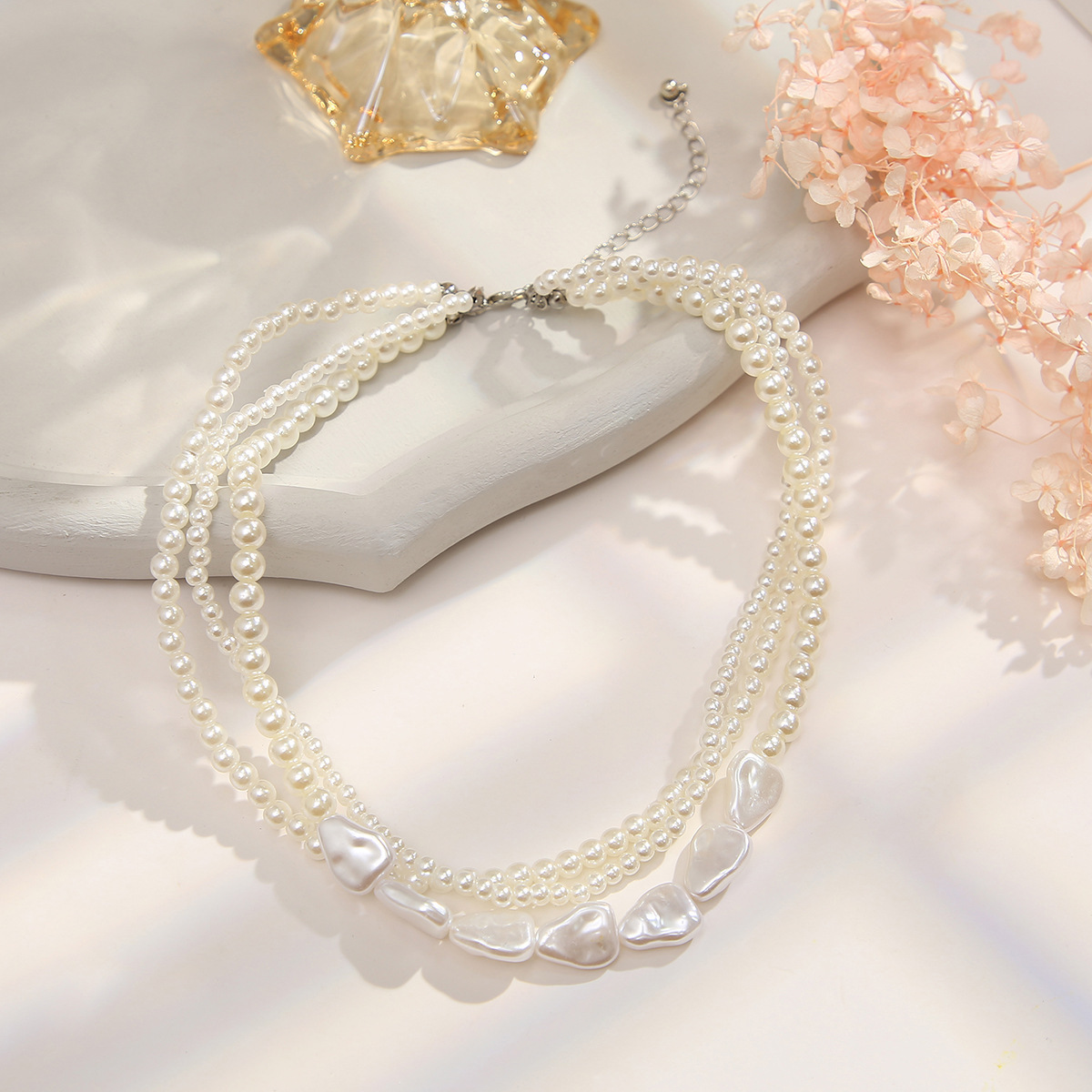 Retro-style pearl-inspired necklace design with layered chains and a collarbone-length style – a simple yet sophisticated necklace.