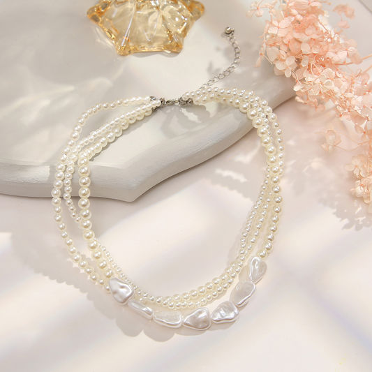 Retro-style pearl-inspired necklace design with layered chains and a collarbone-length style – a simple yet sophisticated necklace.