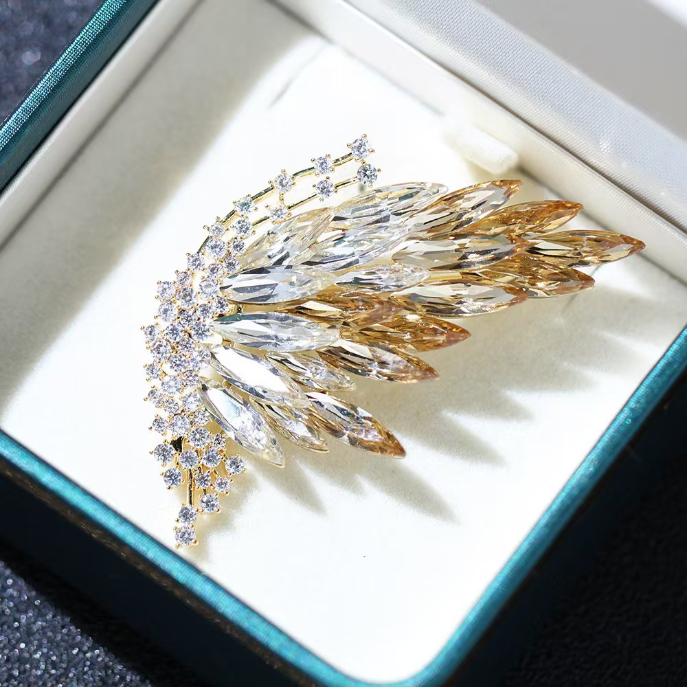 Half-butterfly brooch with elegant gradient crystal design; fashionable insect-shaped brooch with gold plating.
