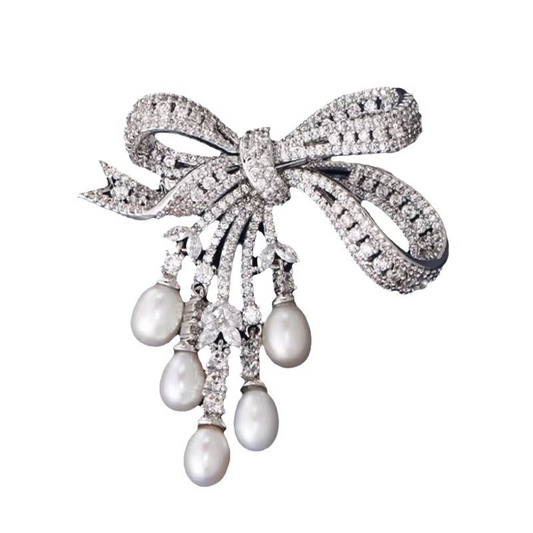 A delicate and luxurious brooch with bow-shaped tassels and a slightly set zirconia embellishment, along with freshwater pearl pins as accessories.